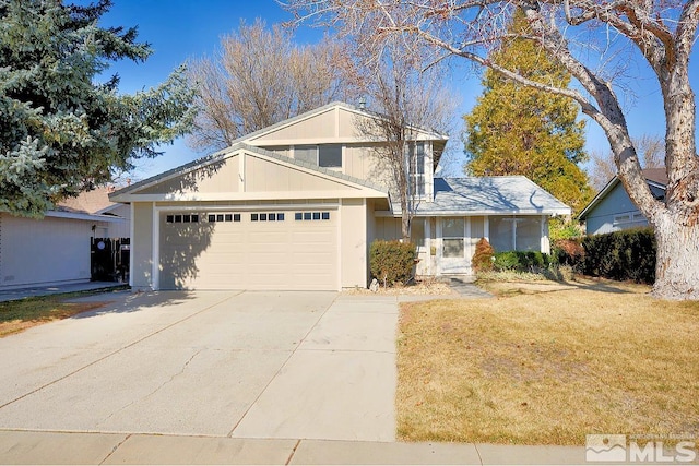 traditional-style home with a garage, driveway, and a front lawn