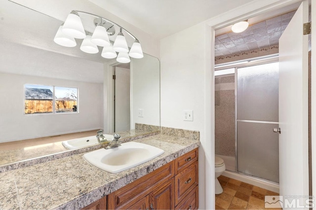 full bathroom with vanity, a shower stall, and toilet