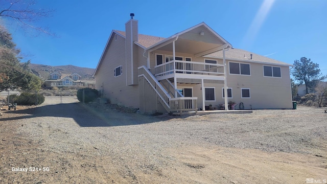 back of property featuring a chimney and stairway