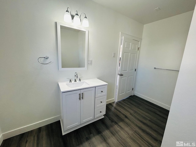 bathroom with vanity, baseboards, and wood finished floors