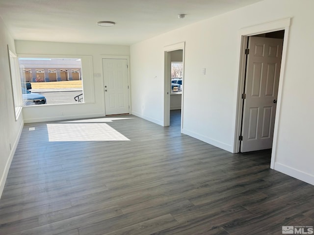 foyer entrance with dark wood-style floors and baseboards