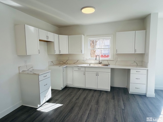 kitchen featuring dark wood finished floors, a sink, and white cabinetry