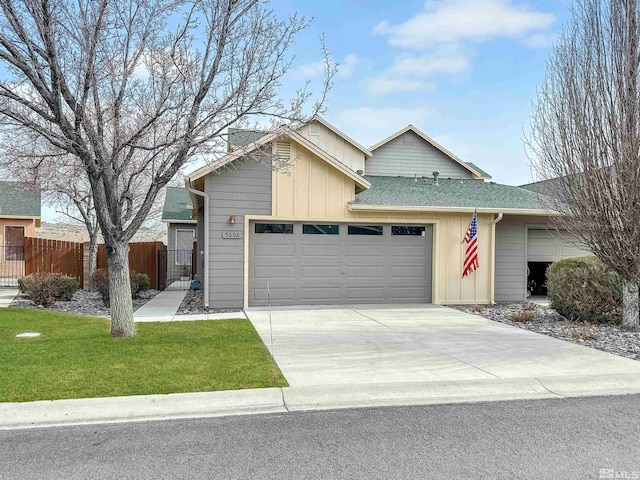 ranch-style home featuring roof with shingles, an attached garage, fence, driveway, and a front lawn