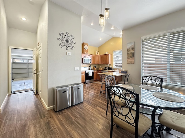 dining room with dark wood-style floors, vaulted ceiling, and baseboards