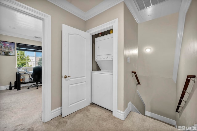 laundry room with light carpet, stacked washing maching and dryer, laundry area, and ornamental molding