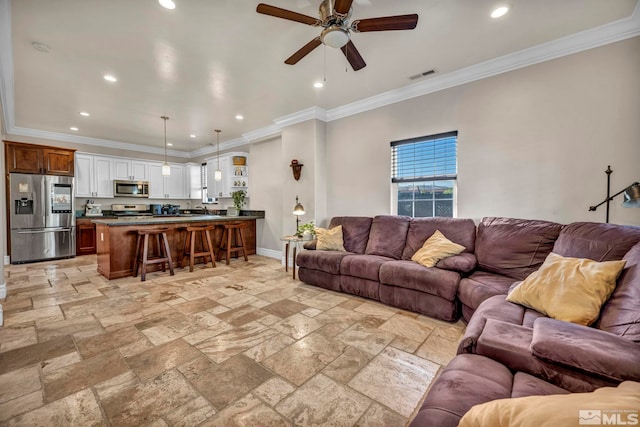 living area with ornamental molding, stone tile flooring, visible vents, and baseboards