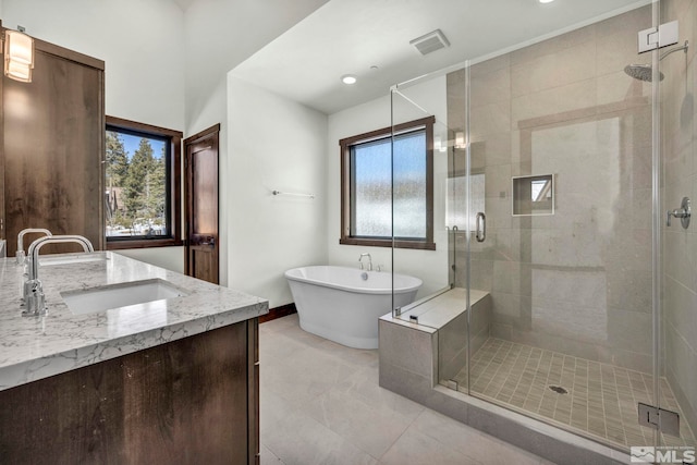 full bath with a sink, visible vents, a freestanding bath, a shower stall, and double vanity