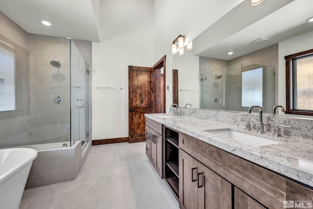 bathroom featuring double vanity, a soaking tub, a sink, and a stall shower