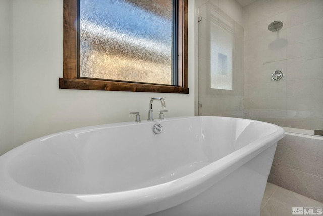 bathroom featuring tile patterned flooring and a freestanding tub