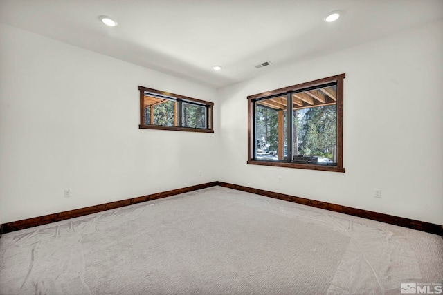 carpeted empty room featuring recessed lighting, visible vents, and baseboards