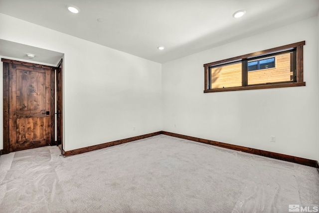 unfurnished room featuring baseboards, recessed lighting, and light colored carpet