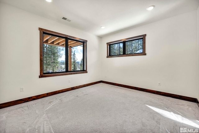 empty room featuring recessed lighting, carpet flooring, visible vents, and baseboards