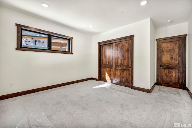 unfurnished bedroom with recessed lighting, light carpet, and baseboards