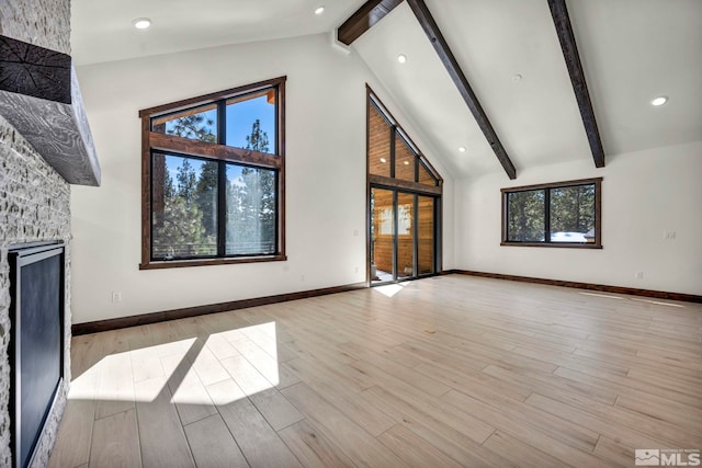 unfurnished living room featuring beamed ceiling, light wood-type flooring, and baseboards