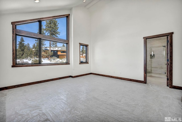 spare room featuring baseboards, high vaulted ceiling, and recessed lighting