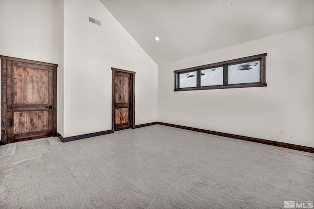 spare room with high vaulted ceiling, visible vents, and baseboards