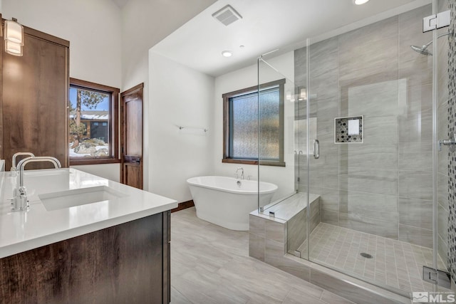 bathroom with visible vents, a freestanding bath, vanity, and a shower stall