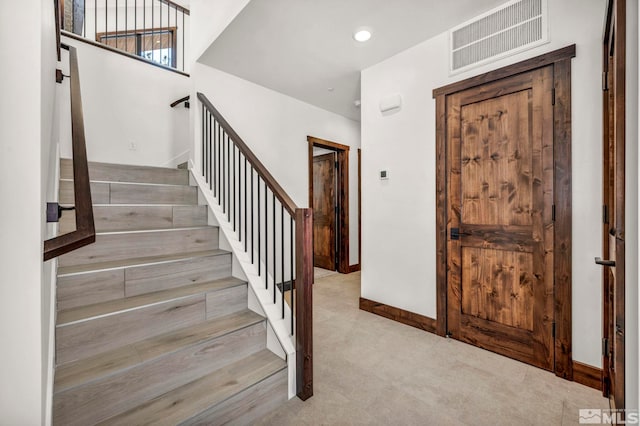 stairway with carpet floors, recessed lighting, visible vents, and baseboards