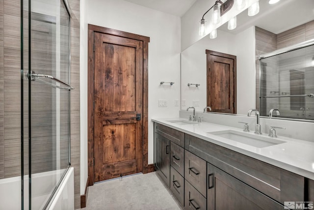 bathroom featuring enclosed tub / shower combo, double vanity, and a sink