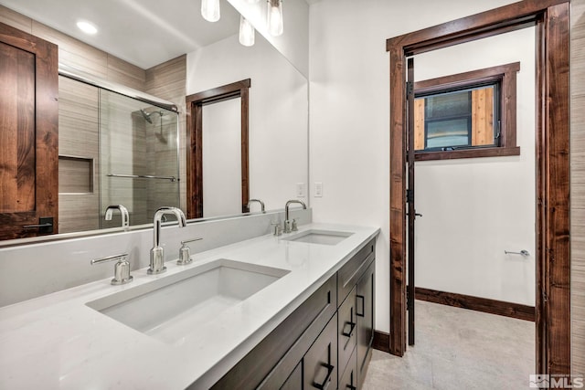 full bath with tile patterned flooring, a sink, baseboards, and double vanity