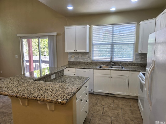 kitchen with a center island, white appliances, white cabinets, and a sink