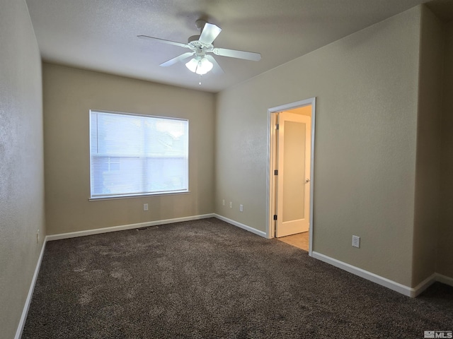 carpeted empty room with ceiling fan and baseboards