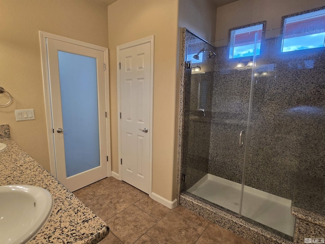 full bath with double vanity, tile patterned flooring, a sink, and a shower stall