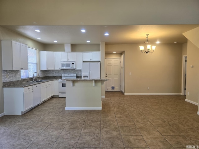 kitchen featuring white appliances, dark stone counters, decorative light fixtures, a center island, and a sink