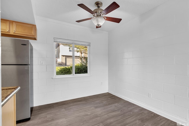 interior space featuring dark wood-style floors, ceiling fan, and freestanding refrigerator