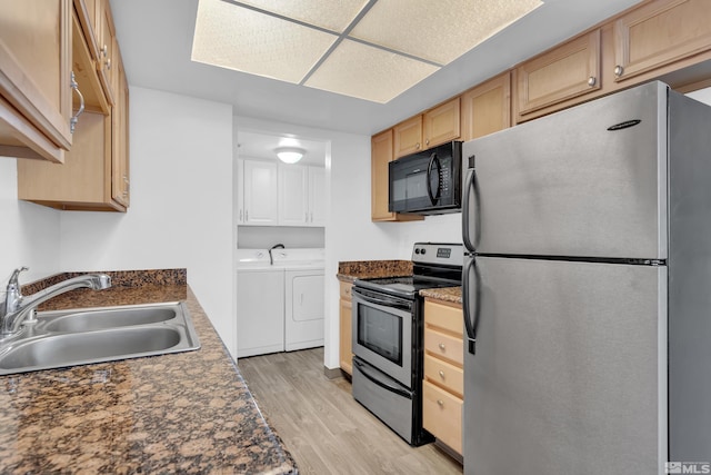 kitchen featuring washer and clothes dryer, stainless steel appliances, light brown cabinetry, light wood-style floors, and a sink