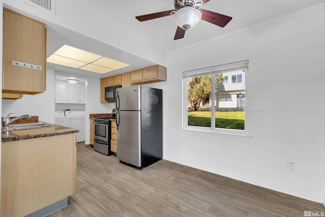 kitchen with stainless steel appliances, separate washer and dryer, a sink, visible vents, and light brown cabinetry