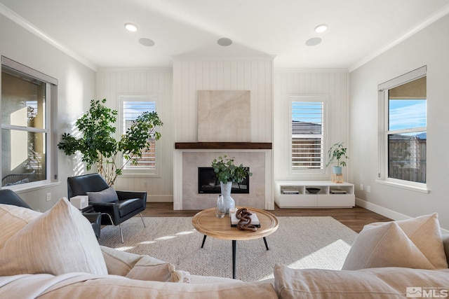 living area with a fireplace, baseboards, dark wood finished floors, and crown molding