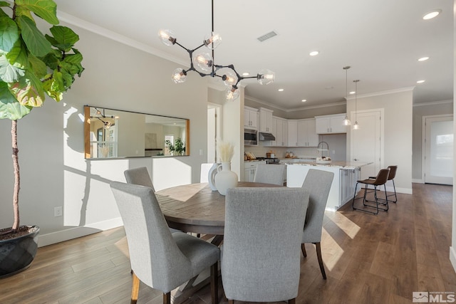 dining room with ornamental molding, dark wood finished floors, visible vents, and baseboards