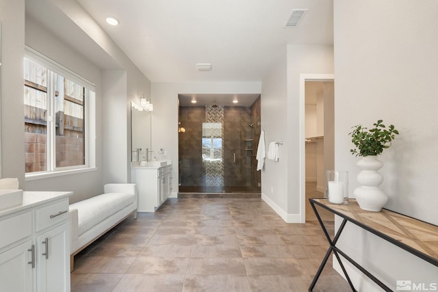 full bath featuring visible vents, a walk in closet, a wealth of natural light, and vanity