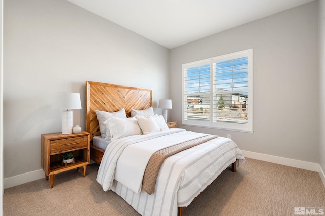 bedroom featuring light colored carpet and baseboards