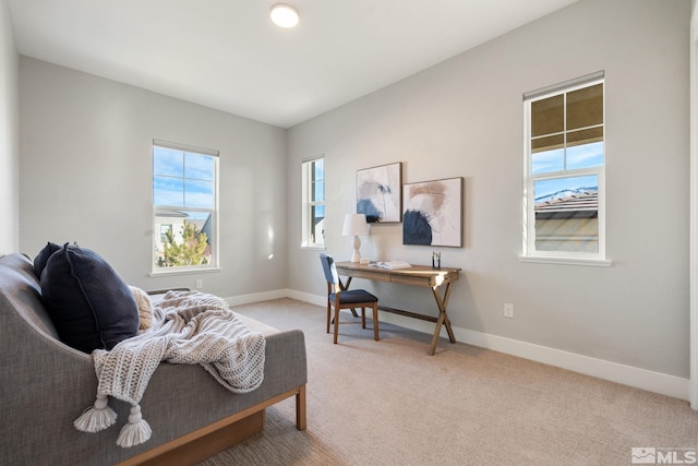 office area featuring light carpet and baseboards