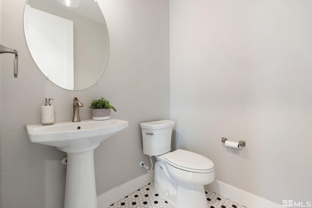 bathroom featuring tile patterned flooring, toilet, and baseboards