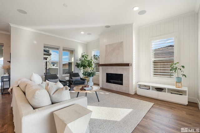 living area featuring recessed lighting, a tiled fireplace, dark wood finished floors, and crown molding