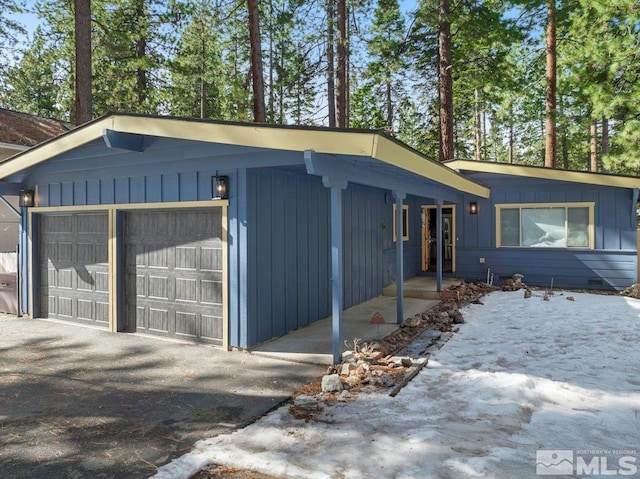 view of front of property with board and batten siding, crawl space, and a garage