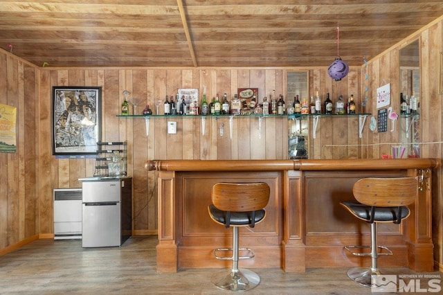 bar with radiator heating unit, wood ceiling, wood walls, and a dry bar