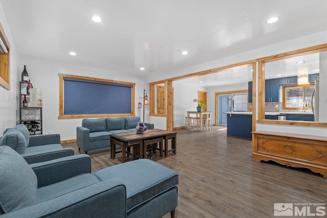 living area with dark wood-type flooring and recessed lighting