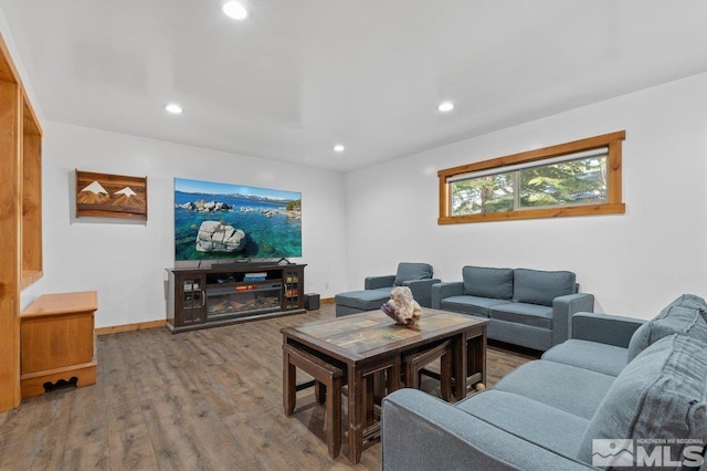 living area with baseboards, a glass covered fireplace, wood finished floors, and recessed lighting