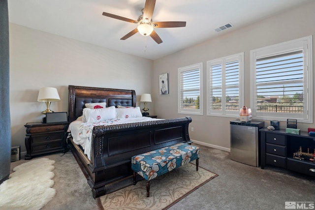 bedroom featuring visible vents, baseboards, a ceiling fan, freestanding refrigerator, and carpet floors