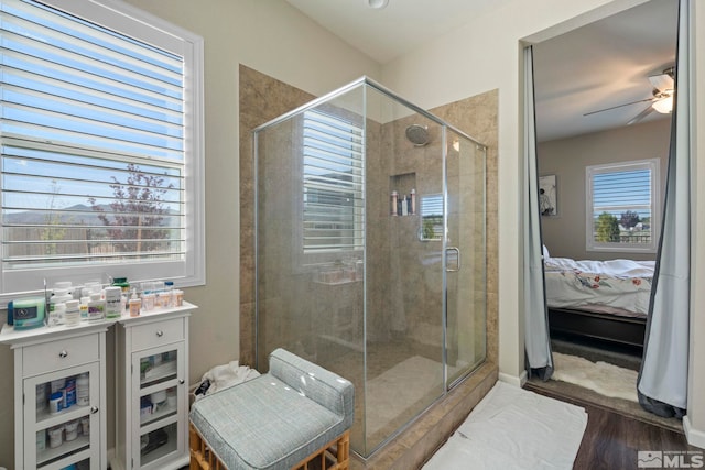 ensuite bathroom with a stall shower, ceiling fan, wood finished floors, and ensuite bathroom