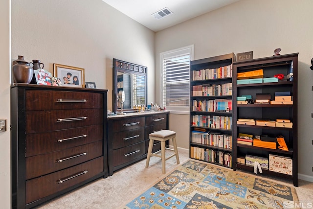 interior space featuring baseboards, visible vents, and light colored carpet