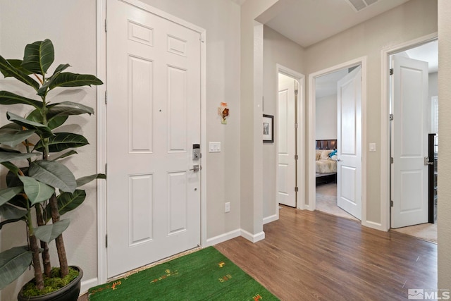 entrance foyer with dark wood-style flooring, visible vents, and baseboards