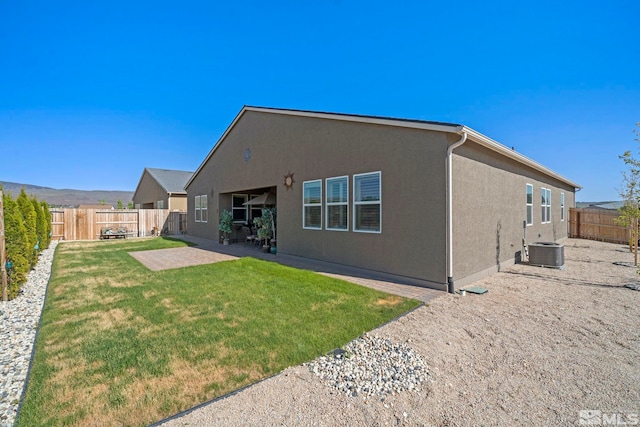 rear view of house with a patio, a yard, a fenced backyard, and stucco siding