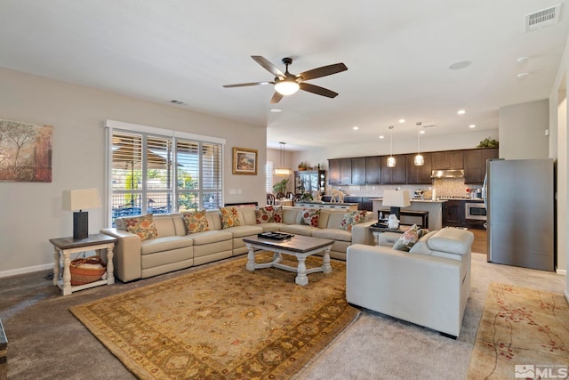 living room with baseboards, recessed lighting, visible vents, and a ceiling fan