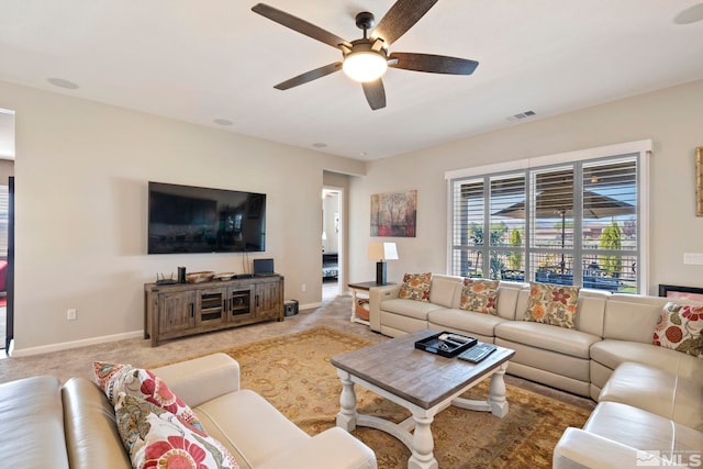 living area with carpet, visible vents, ceiling fan, and baseboards