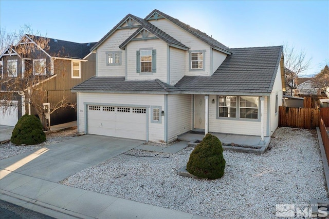 view of front of home featuring a garage, concrete driveway, and fence